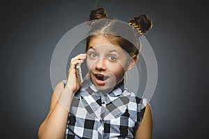 Closeup Portrait of happy girl with mobile or cell phone on gray background