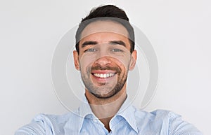 Closeup portrait of happy handsome young male smiling with healhty toothy smile looking at the camera, making self portrait.