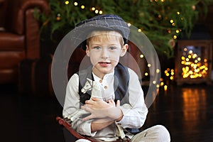 Closeup portrait Happy little boy hugs Figurine of a rocking horse  on Christmas. Smiling Little blond boy in a white shirt with a