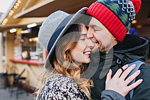 Closeup portrait happy lovely couple chilling outdoor on street on christmas time. Romantic moments,taking care, real