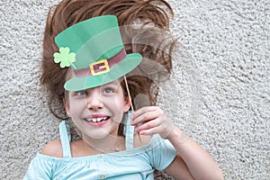 Closeup portrait of a happy preteen caucasian girl in an emerald leprechaun St. Patrick`s Day hat