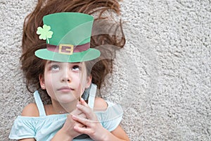 Closeup portrait of a happy preteen caucasian girl in an emerald leprechaun St. Patrick`s Day hat