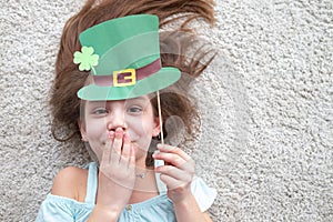 Closeup portrait of a happy preteen caucasian girl in an emerald leprechaun St. Patrick`s Day hat