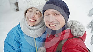 Closeup portrait of happy smiling young couple walking in snowy winter park at cold winter day. man and woman lovely