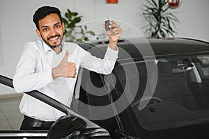 Closeup portrait happy, smiling, young man, buyer showing keys of his new car