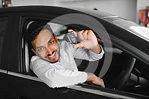Closeup portrait happy, smiling, young man, buyer showing keys of his new car