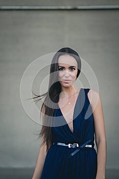 Closeup portrait of a happy young brunette teenage girl outdoor. concrete wall on background