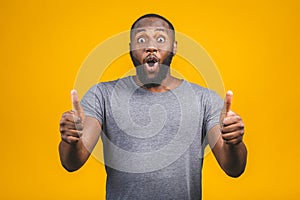 Closeup portrait of happy young handsome man looking shocked surprised open mouth eyes, isolated on yellow background. Positive