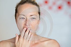 Closeup portrait headshot of sleepy young woman covering her wide open mouth while yawning by her palm. Face expression