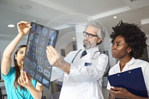 Closeup portrait of intellectual doctors healthcare personnel with white labcoat, looking at lungs x-ray radiographic image, ct