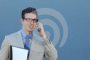 Closeup portrait of laughing young business man with glasses and wide open mouth talking on mobile phone outdoors
