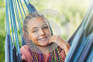 Closeup portrait of laughing young girl with colorful braids