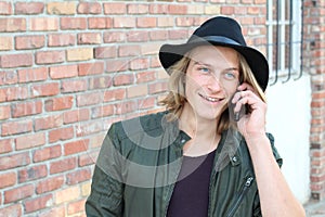 Closeup portrait of laughing young man talking on mobile phone outdoors