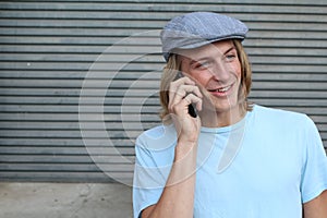 Closeup portrait of laughing young man talking on mobile phone outdoors