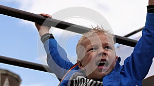 Boy hanging on monkey bars