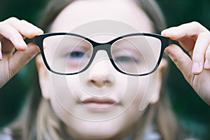 Closeup portrait of little girl  with myopia correction glasses.