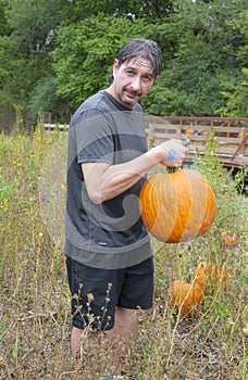 Closeup portrait of a man holding a pumpkin