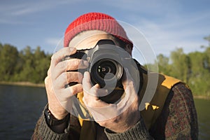 Closeup Portrait of a Man Taking a Picture with Professional Photo Camera on a Lake.