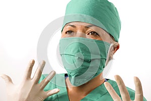 Closeup portrait of mature attractive and happy medicine doctor woman or hospital nurse in medical scrubs latex gloves and mask