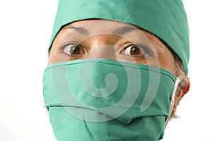 Closeup portrait of mature attractive medicine doctor woman or hospital nurse in medical scrubs and mask looking intense to camera