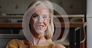 Closeup portrait middle-aged woman with blonde hair and toothy smile