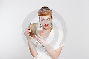 Closeup portrait middle aged woman opening gift box very upset at what she received, isolated white background. Negative human