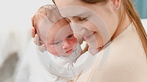 Closeup portrait of mother's and baby face against big window in bedroom