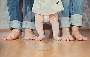 Closeup portrait of a mother teaching baby to walk indoors
