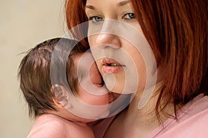 Closeup portrait of mother with worried face embracing newborn baby daughter. Post-natal depression concept photo