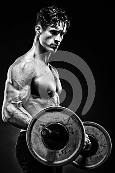 Closeup portrait of a muscular man workout with barbell at gym.