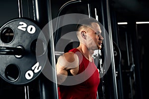 Closeup portrait of a muscular man workout with barbell at gym. Brutal bodybuilder athletic man with six pack, perfect