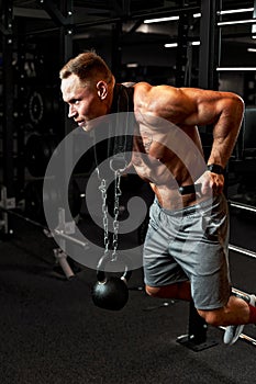 Closeup portrait of a muscular man workout with barbell at gym. Brutal bodybuilder athletic man with six pack, perfect