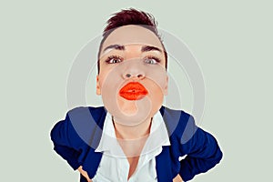 Closeup portrait of nerdy young funny distorted woman face with big red lips trying to blow a kiss to you camera, isolated light