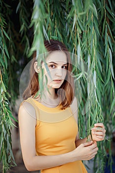 Closeup portrait of pensive sad beautiful young Caucasian woman girl in yellow dress with red hair, brown eyes, looking in camera