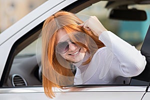 Closeup portrait of pissed off displeased angry aggressive woman driving a car shouting at someone with finger to temple gesture