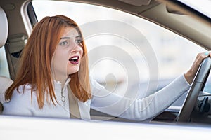 Closeup portrait of pissed off displeased angry aggressive woman driving a car shouting at someone. Negative human expression