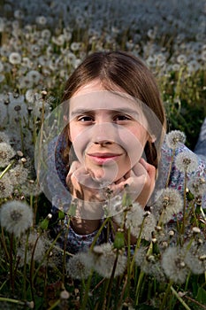 Closeup Portrait of Pretty Girl Resting on Dandelion Field on Sunny Spring Day