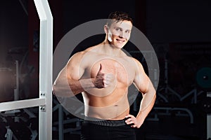 Closeup portrait of professional bodybuilder workout with barbell at gym. Confident muscular man training . Looking