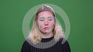 Closeup portrait of sad young pretty blonde caucasian female being depressed looking at camera with background isolated