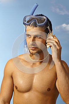 Closeup portrait of scuba diver with seashell