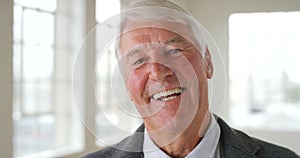 Closeup portrait of a senior man smiling and laughing alone. Face of a cheerful and joyful retired man looking confident