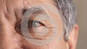 Closeup portrait of a senior mans eye at the optometrist. Side of a retired males face with zoom on his eyeball and lens