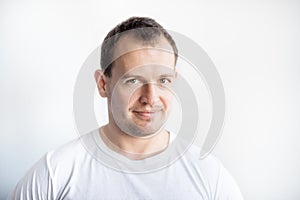 Closeup portrait of serious 30 years old caucasian white man on white background in white t-shirt. Confident happy smart modern