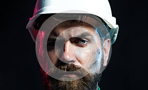 Closeup portrait of serious bearded architect, engineer or designer in protective hard hat. Industrial or mechanical