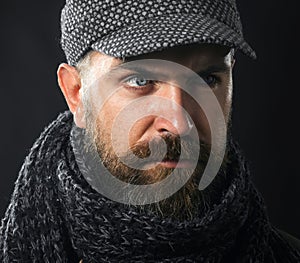 Closeup portrait serious bearded man in gray cap and scarf. Men fashion. Fashionable handsome man with beard and