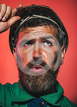 Closeup portrait of serious builder, foreman or repairman in safety helmet. Mechanical or industrial worker in