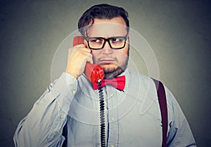 Closeup portrait of a serious grumpy looking businessman talking on telephone