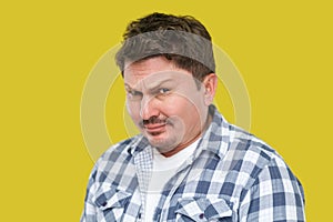 Closeup portrait of serious handsome middle aged business man in casual checkered shirt standing and looking at camera with