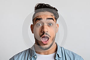 Closeup portrait of shocked young arab man looking at camera with astonishment