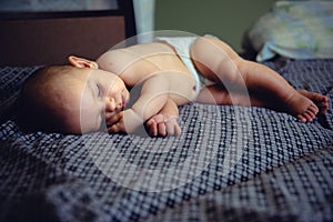 Closeup portrait of sleeping on the grey bed in diaper innocence